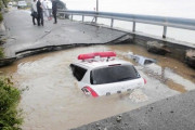 水がたまった巨大穴に軽自動車とパトカー転落