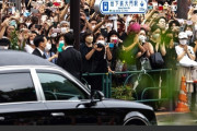 キャプション「安倍氏の棺を乗せた車に手を合わせる人々」