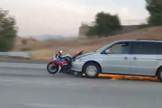 どうしてこうなった　バイクに追突した状態で火花を散らしながら走るバン