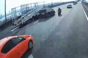 【動画】高速を走行中のバイク乗り、合流するトレーラーを追い越そうとした車にぶつけられて死にかける