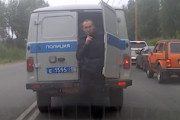 おどロシア。渋滞にはまった警察の移送車からこっそりと逃げ出す男の映像。
