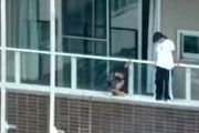 【東京】高層マンションのバルコニーの外側に立って危険な遊びをする子供が撮影される。