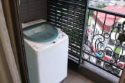 洗濯機、ベランダに置いてる人。