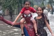 インドのスパイダーマンが豪雨で冠水した道路で困っている人々を助ける