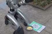 道端でひざまずいて物乞いをする中国のロボット